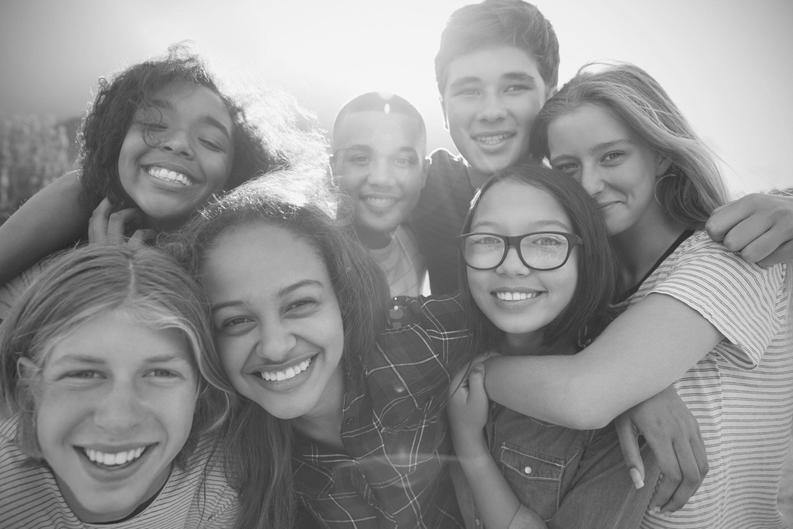 Group of teens, smiling and hugging