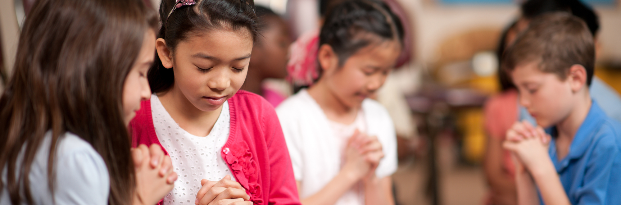 Young schoolchildren in elementary school praying.