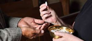 Hand passing the Eucharistic bread at Communion
