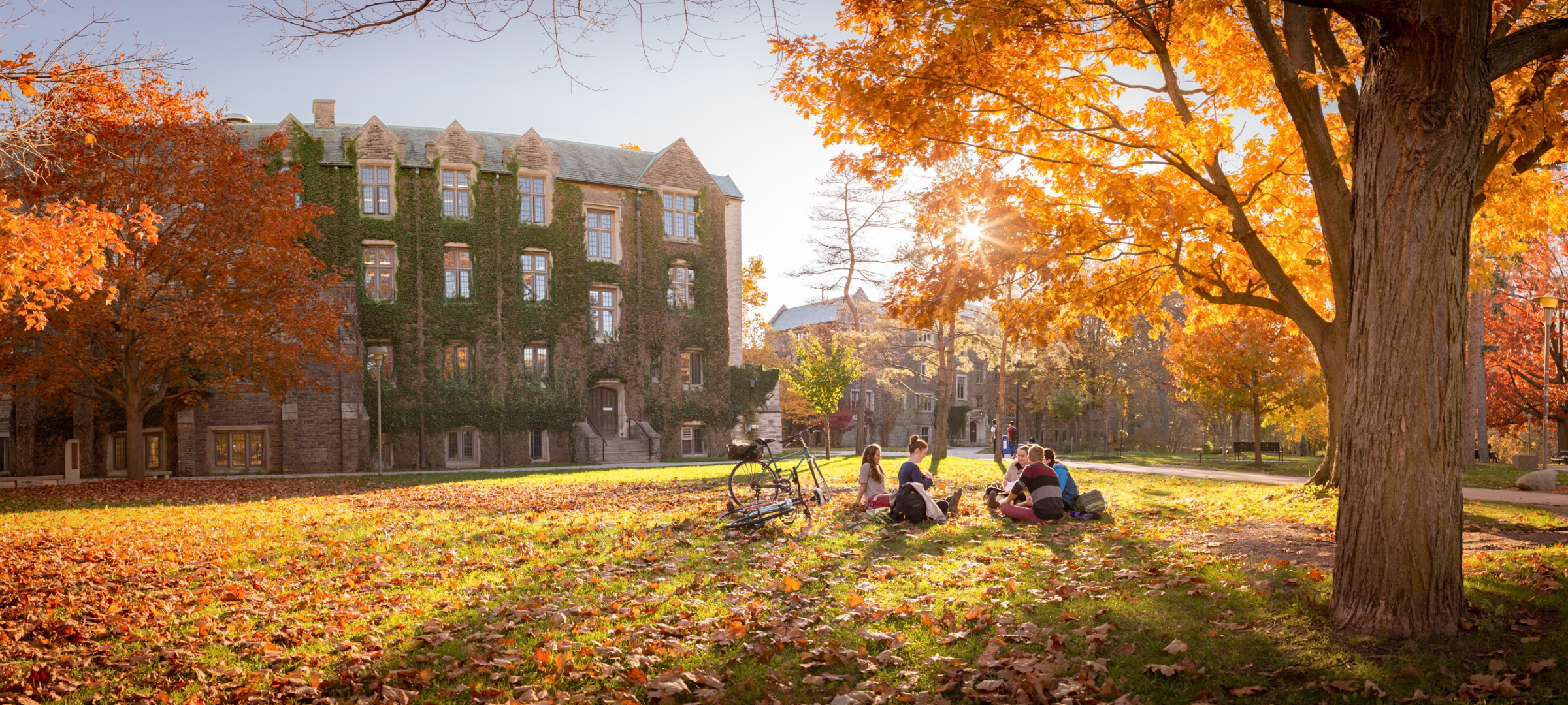 Catholic Campus Ministry - a group of students are gathered together outside in the falltime