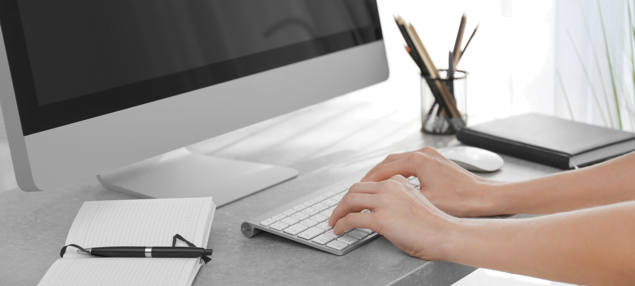 Hands poised on a keyboard at a desktop computer